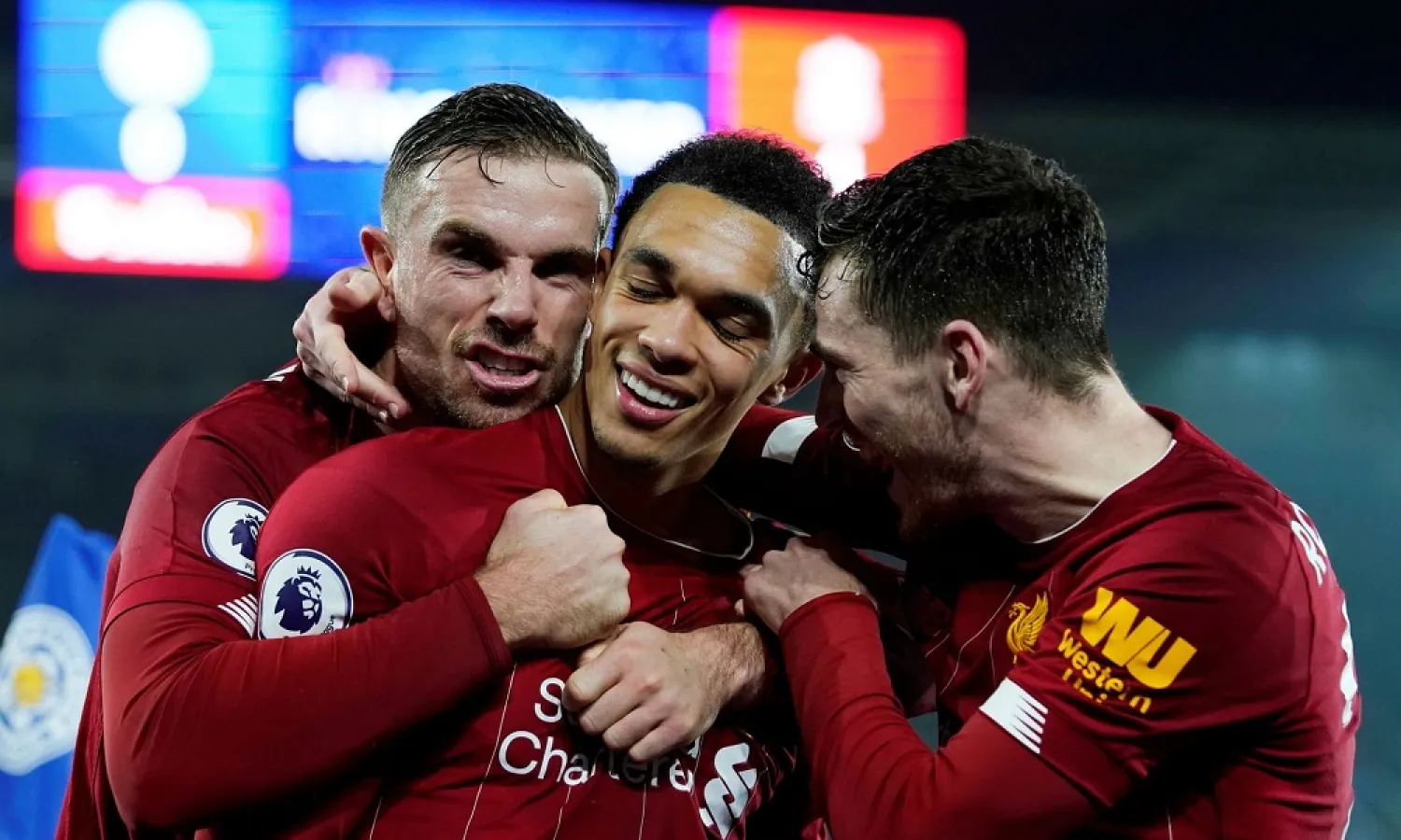 Liverpool’s Trent Alexander-Arnold (center) celebrates with Jordan Henderson and Andrew Robertson after scoring the final goal in the 4-0 win at Leicester. (Reuters)