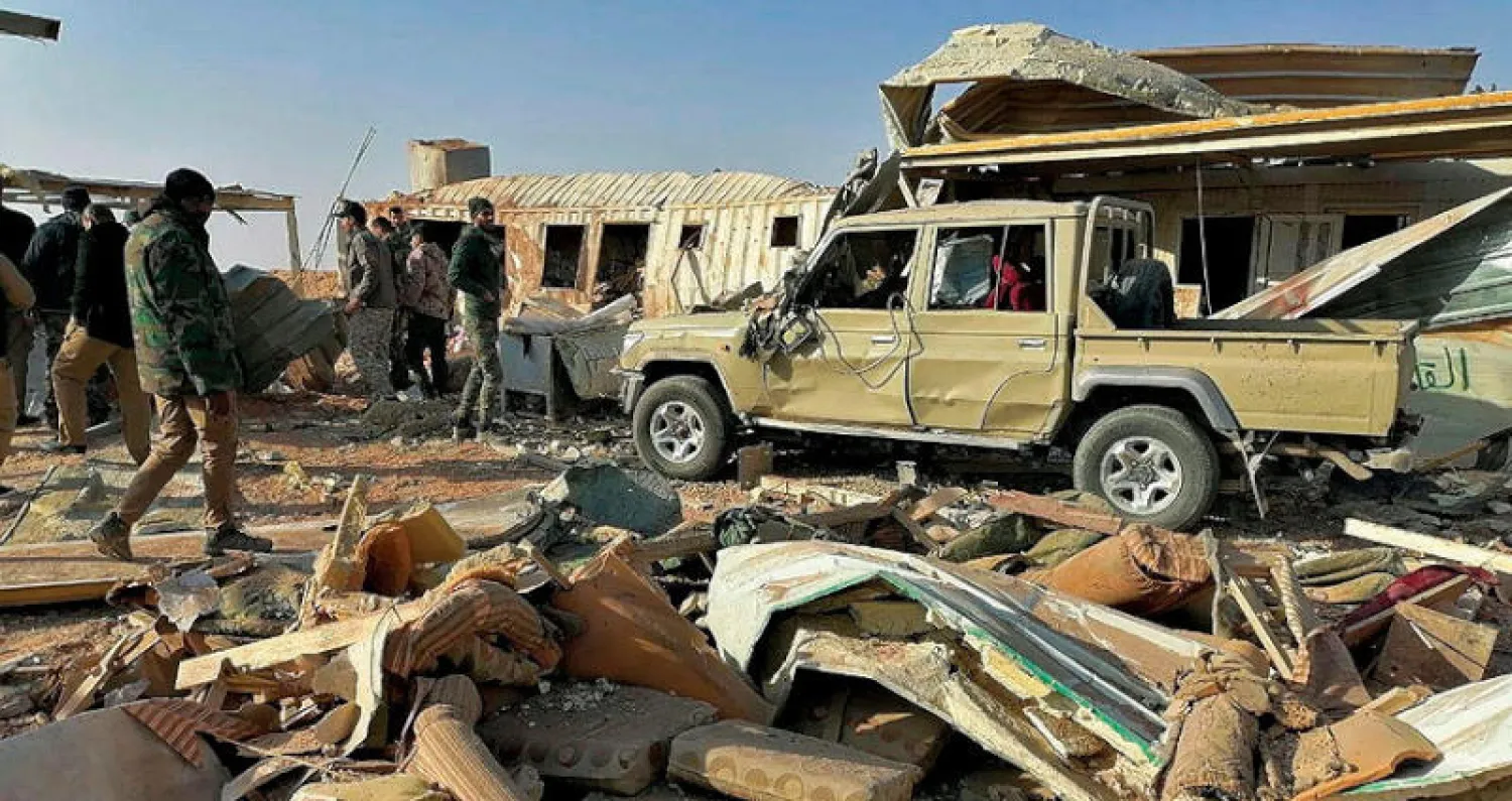 مقاتلون من «كتائب حزب الله» يعاينون أمس الدمار الذي خلفه القصف الأميركي أول من أمس لإحدى قواعدهم غرب العراق (أ.ب)