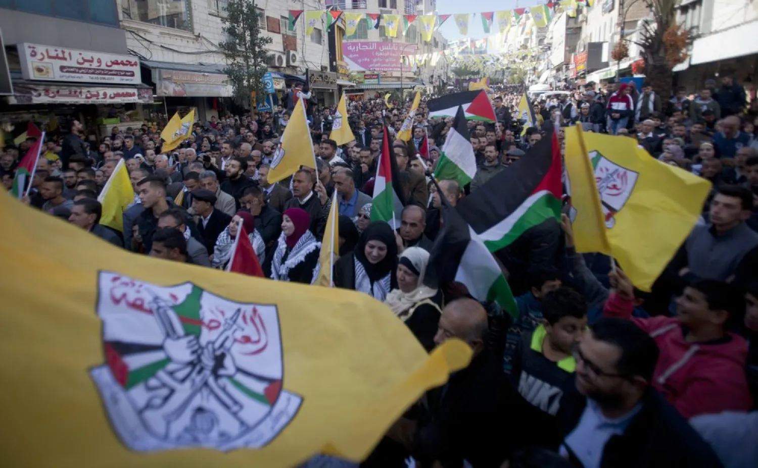 Palestinian wave Fatah and Palestinian flags during a celebration marking the 55th anniversary of the Fatah movement in the West Bank city of Ramallah, Tuesday, Dec. 31, 2019. (AP)