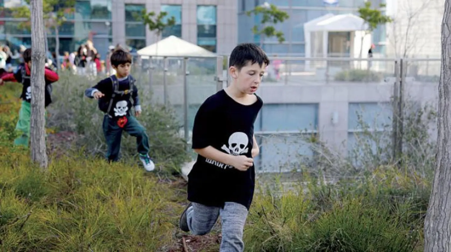 Tehlikeli amblemi taşıyan siyah tişörtlü çocuklar, Tel Aviv yakınlarındaki Laviathan tesisinin faaliyete geçmesini protesto ediyor (Reuters)