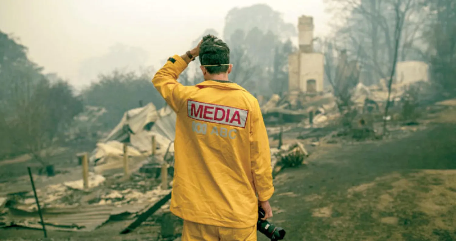 مصور شبكة (إي. بي. سي) يعاين الدمار في بلدة بنيو ساوث ويلز أمس (إ.ب.أ)