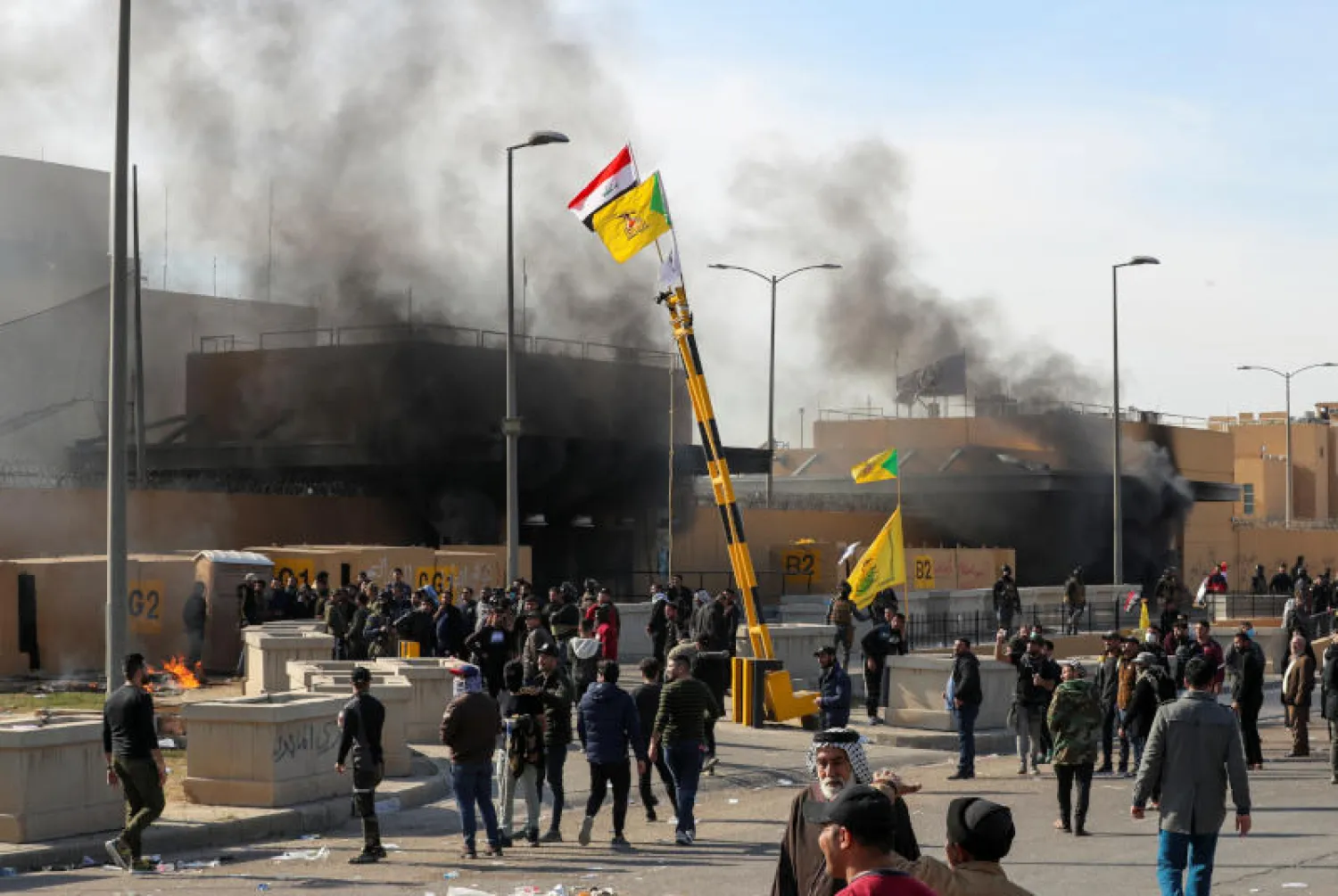 محتجون عراقيون يحيطون بالسفارة الأميركية في بغداد (رويترز)