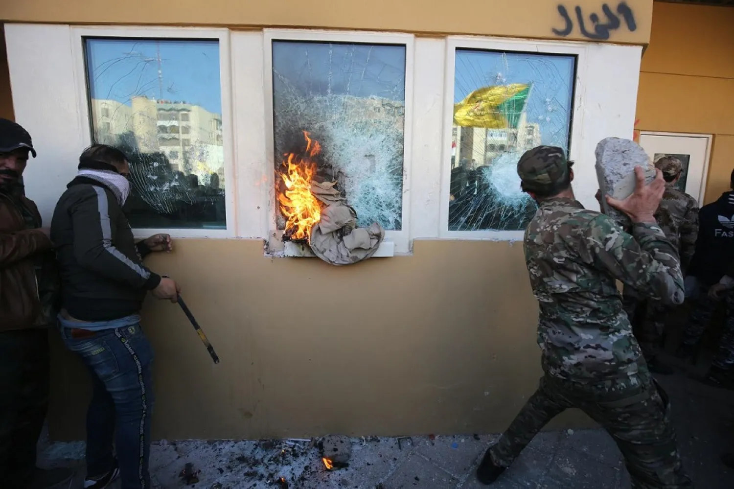 Members of the Popular Mobilization Forces smash the bullet-proof glass of the US embassy in Baghdad. (AFP)