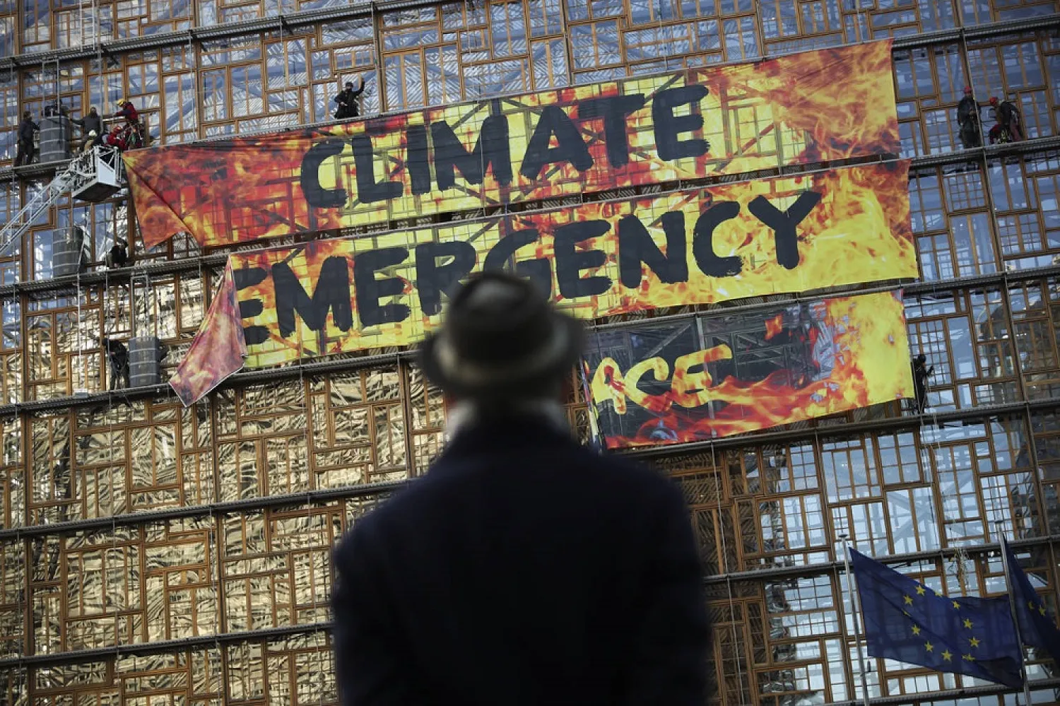 Police and fire personnel move in to remove climate activists and their banner, after they climbed the Europa building during a rally outside an EU summit meeting in Brussels, December 12, 2019. (AP)