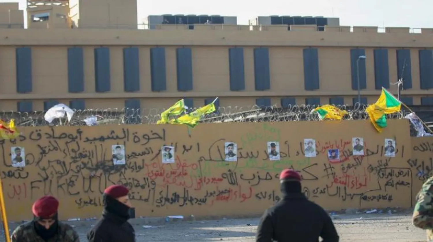 Protestocular tarafından ABD’nin Bağdat Büyükelçiliği duvarına yapıştırılan Hizbullah Tugay unsurlarının fotoğrafları (AFP)