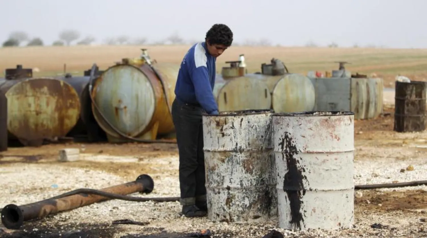 Caption: A youth works at a makeshift oil refinery site in Marchmarin town, southern countryside of Idlib, Syria December 16, 2015. REUTERS/Khalil Ashawi