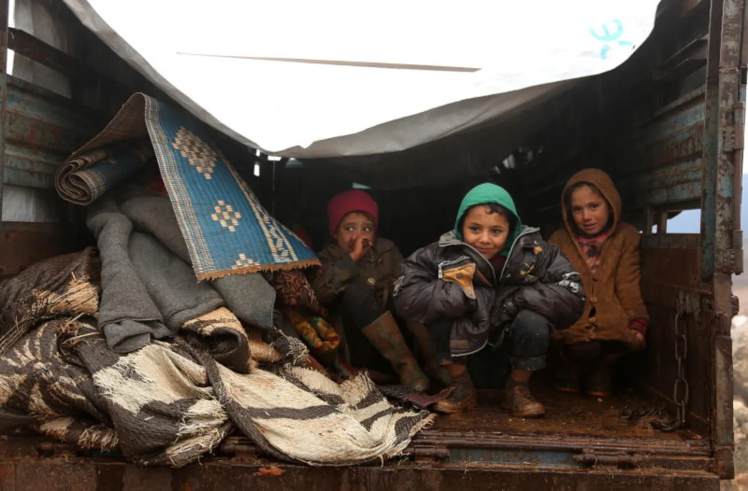 أطفال سوريون من النازحين من معرّة النعمان في اتجاه مناطق أكثر أماناً قرب حدود محافظة إدلب مع تركيا (إ.ب.أ)