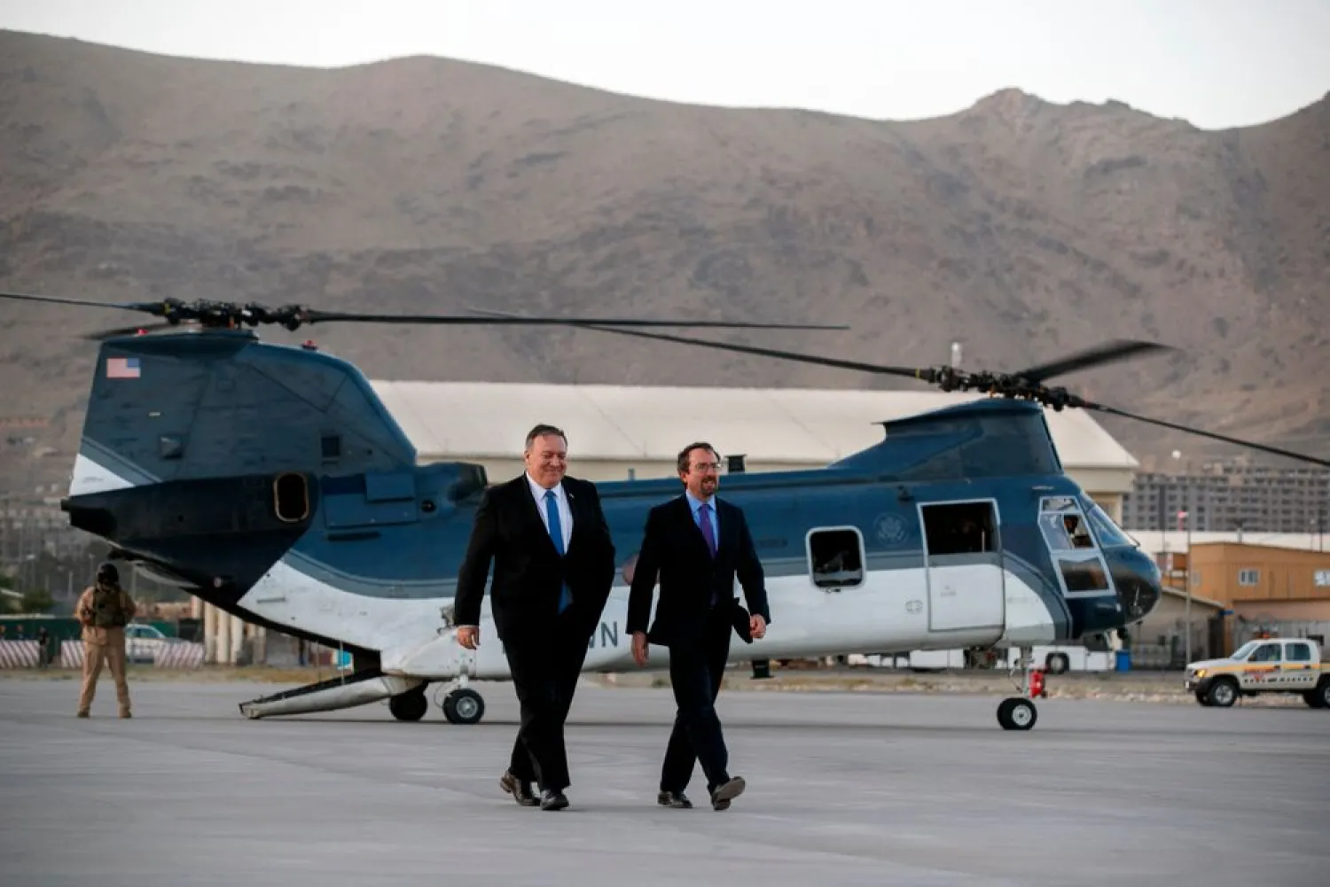 In this June 25, 2019 photo, Secretary of State Mike Pompeo, left, walks from a helicopter with US Ambassador to Afghanistan John Bass. Bass is leaving Afghanistan, ending his two-year tenure as America's ambassador to the war-weary country that began in December 2017. (AP Photo/Jacquelyn Martin, Pool, File)