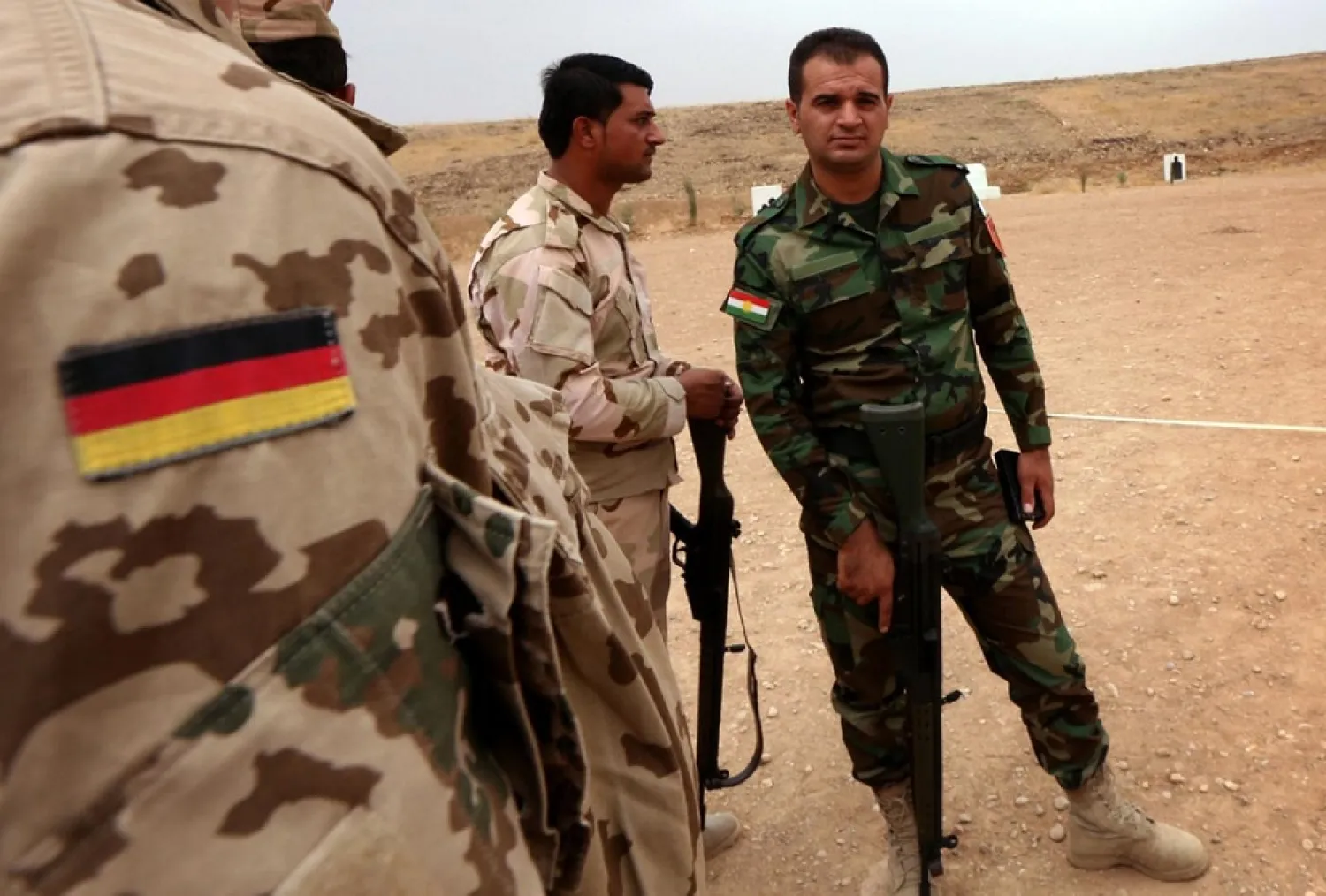 A German military expert (L) speaks with Kurdish Peshmerga fighters during training at a shooting range on October 2, 2014, in Arbil, Iraq. (AFP)