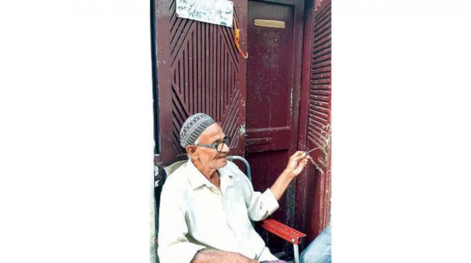 Iskandar Abdulghaffour sits infront of his residence at Crater neighborhood, Aden, Asharq Al-Awsat 
