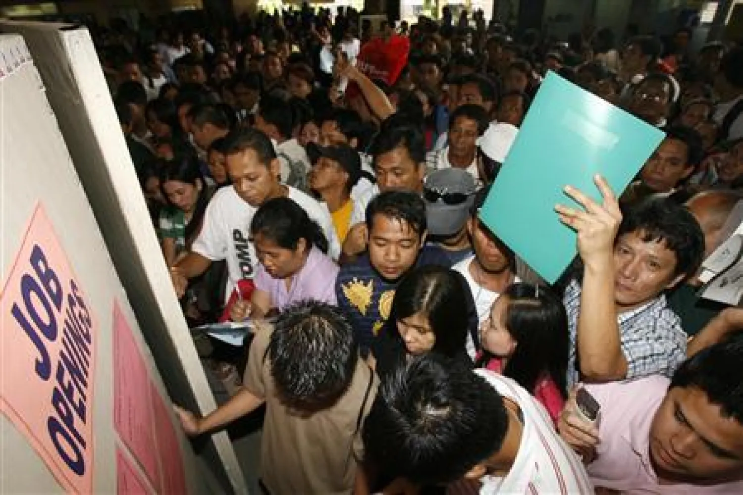 Filipino job seekers look at job openings posted on a board inside a Philippine Overseas Employment Agency (POEA) in Manila February 25, 2009. REUTERS/Romeo Ranoco


