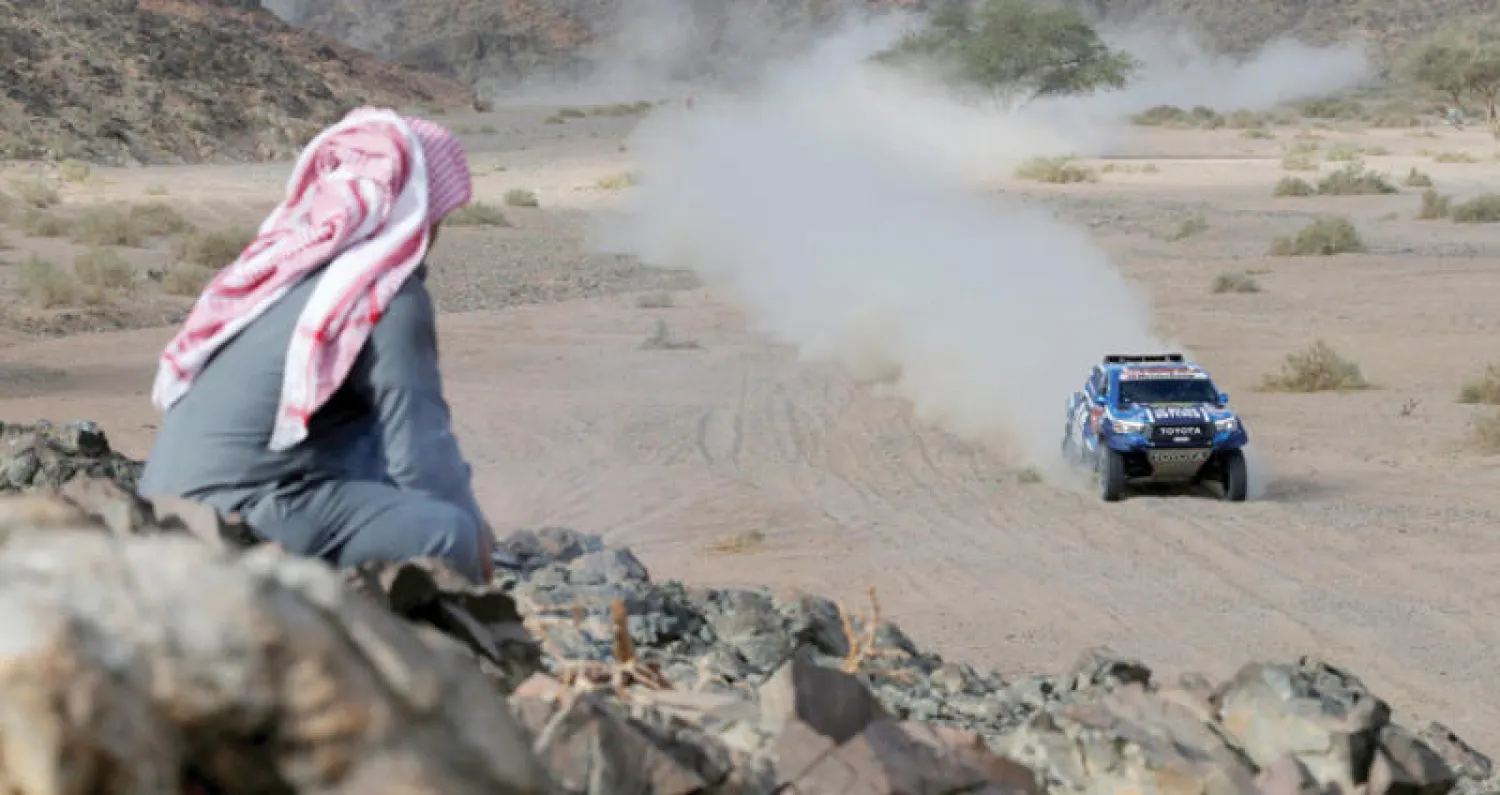 مشجع يتابع منافسات رالي داكار من على أحد المرتفعات (رويترز)