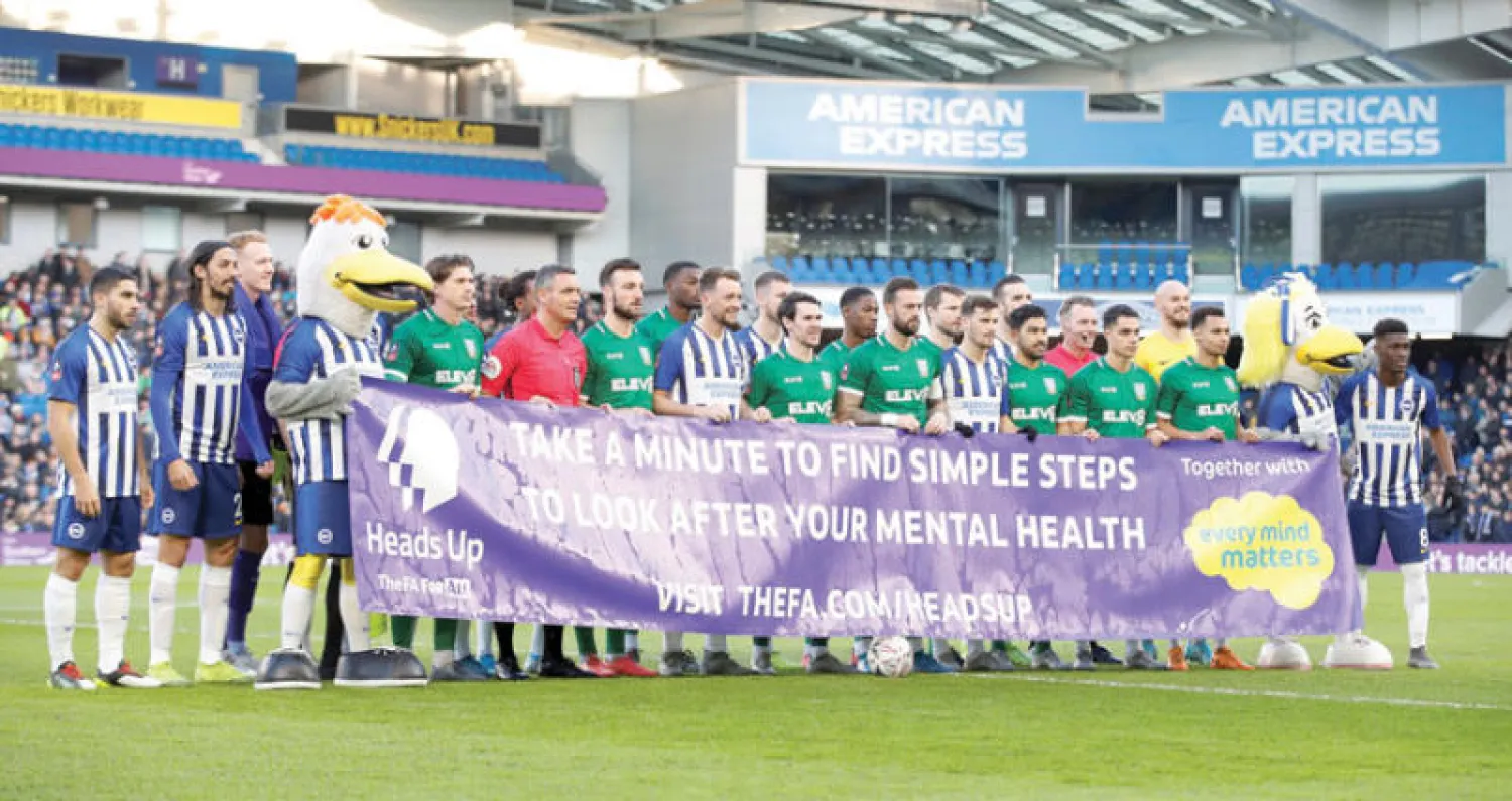 لاعبو برايتون وشيفيلد ونزداي يحملون لافتة تشجع على التفكير في الصحة الذهنية (رويترز)