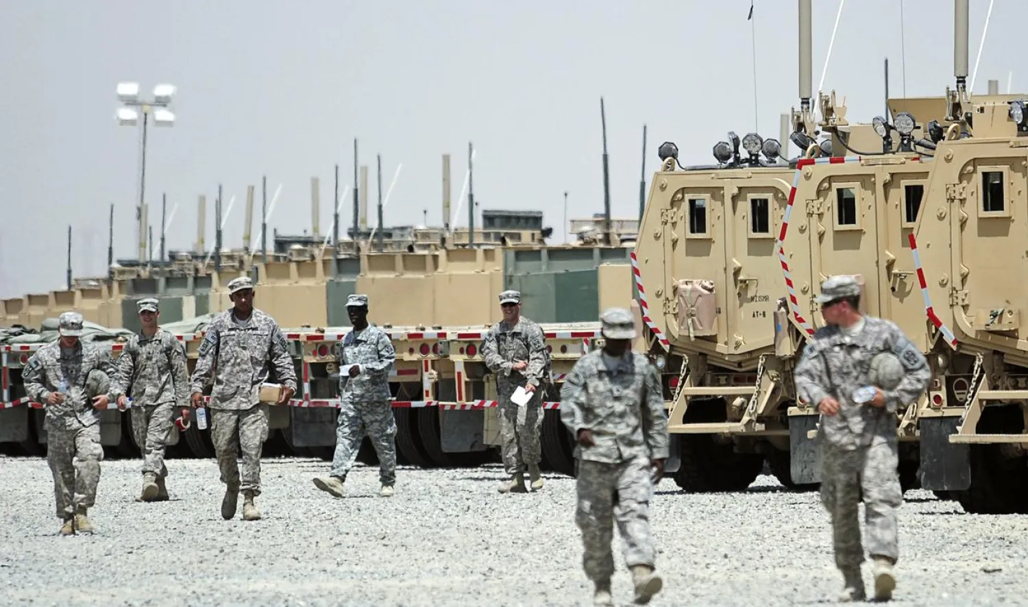 US soldiers walk near vehicles at Camp Arifjan, Kuwait September 1, 2010 as they prepare to head to Iraq following the end of combat missions. (Reuters)