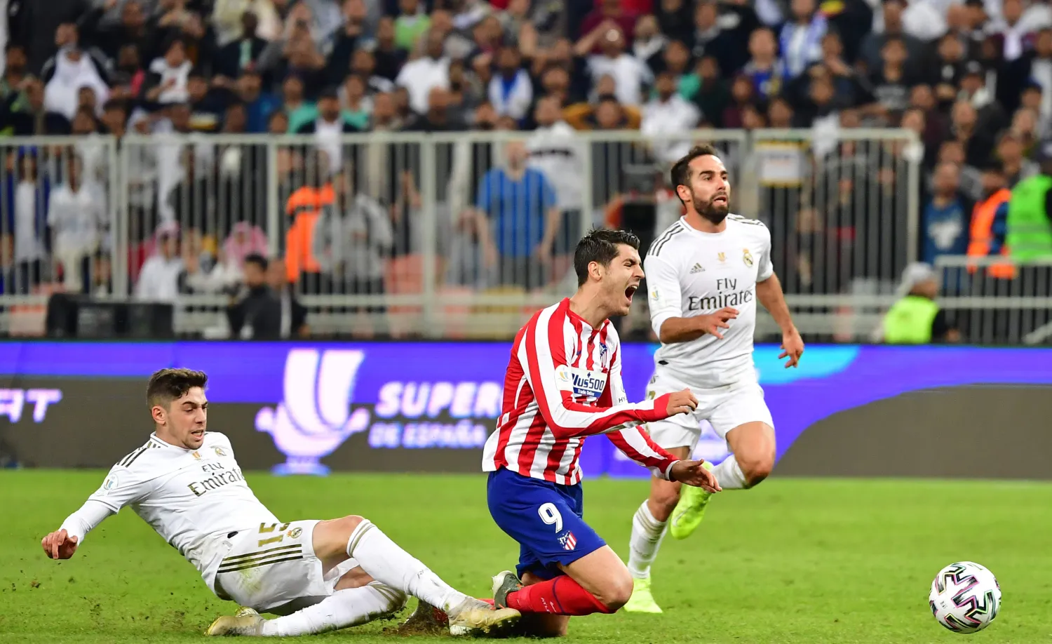 لحظة تدخل لاعب ريال مدريد فيدريكو فالفيردي ضد مهاجم أتليتكو ألفارو موراتا في نهائي السوبر الإسباني (أ.ف.ب)