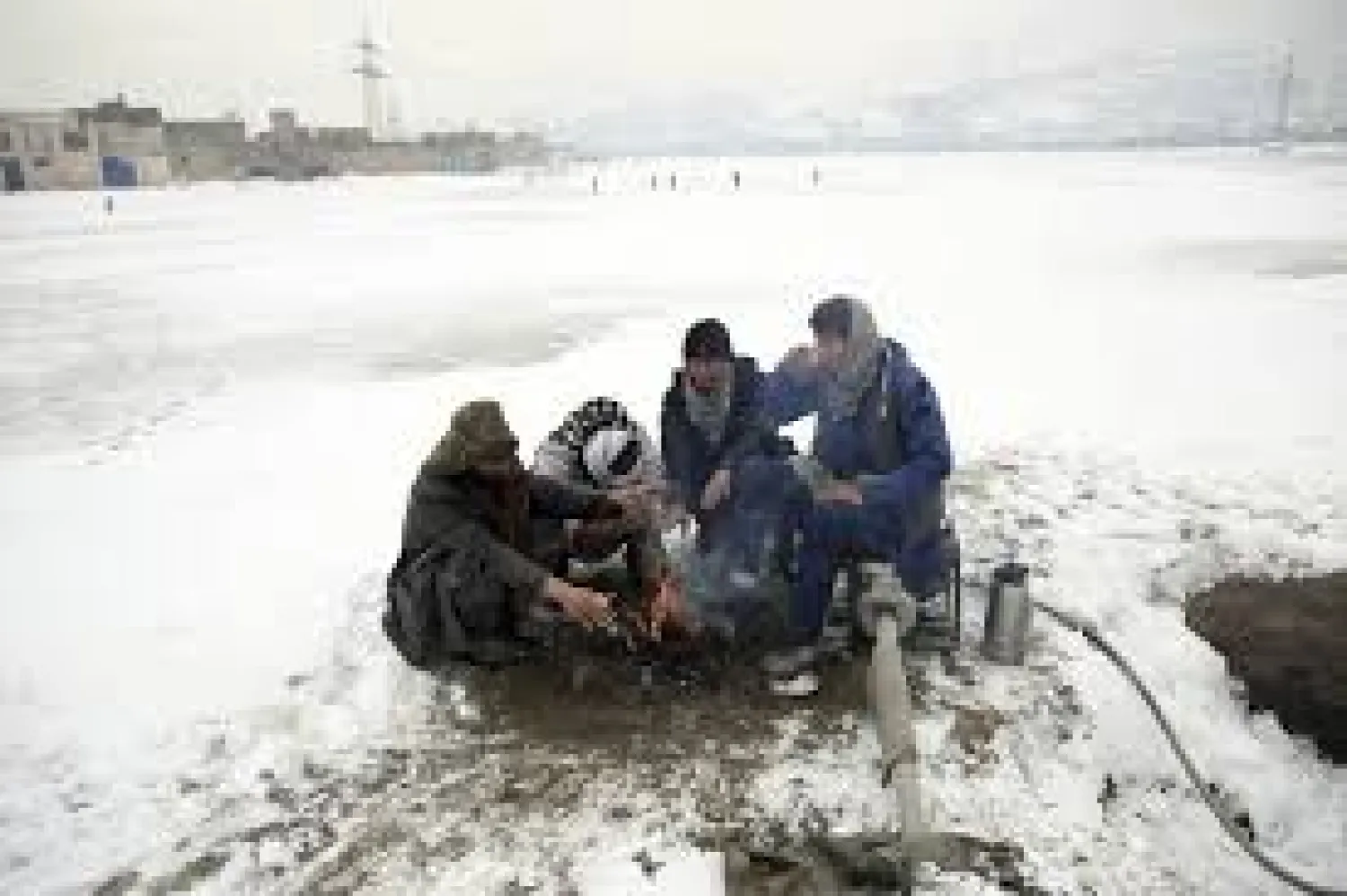 People sit around a fire to warm themselves after heavy snowfall in Kabul, Afghanistan, Tuesday, Jan. 14, 2020. Severe winter weather has struck parts of Afghanistan and Pakistan, with heavy snowfall, rains, and flash floods that left dozens dead, officials said Monday as authorities struggled to clear and reopen highways and evacuate people to safer places. (AP Photo/Rahmat Gul)