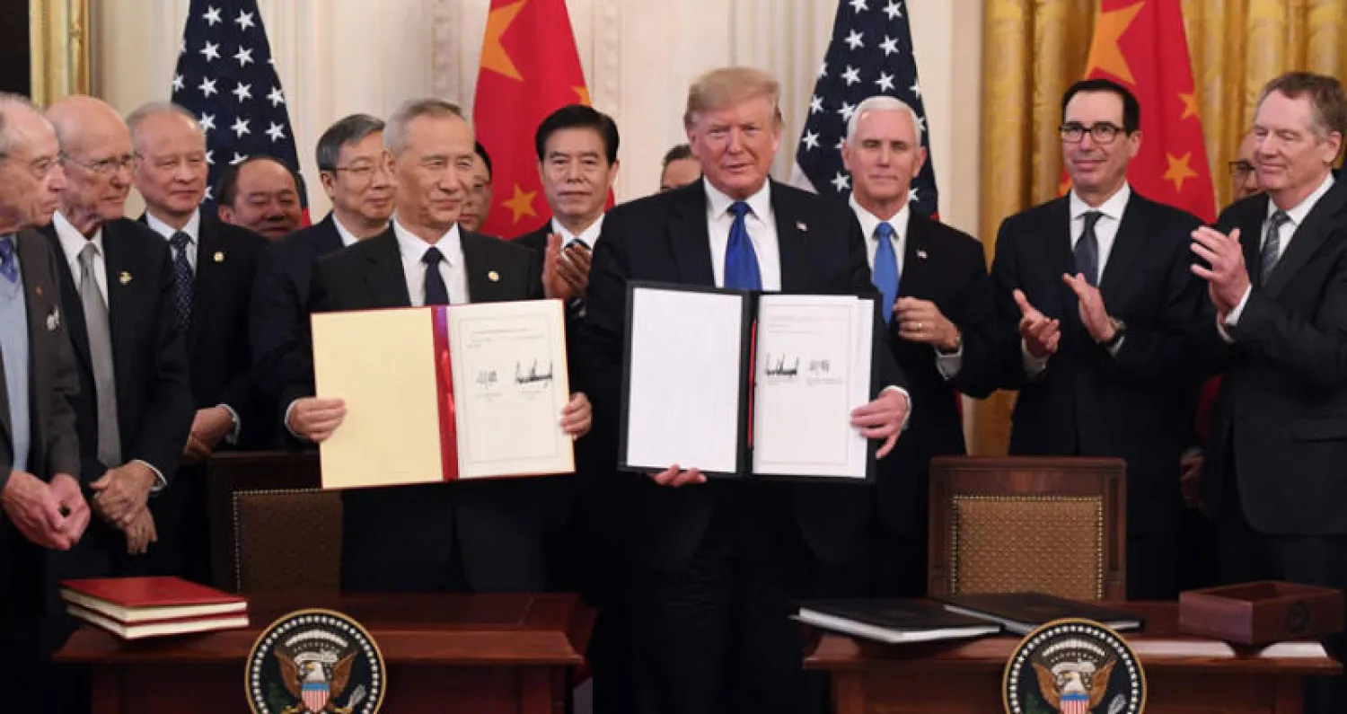 الرئيس الأميركي دونالد ترمب وكبير مفاوضي الصين عقب توقيع الاتفاق في البيت الأبيض أمس (أ.ف.ب)