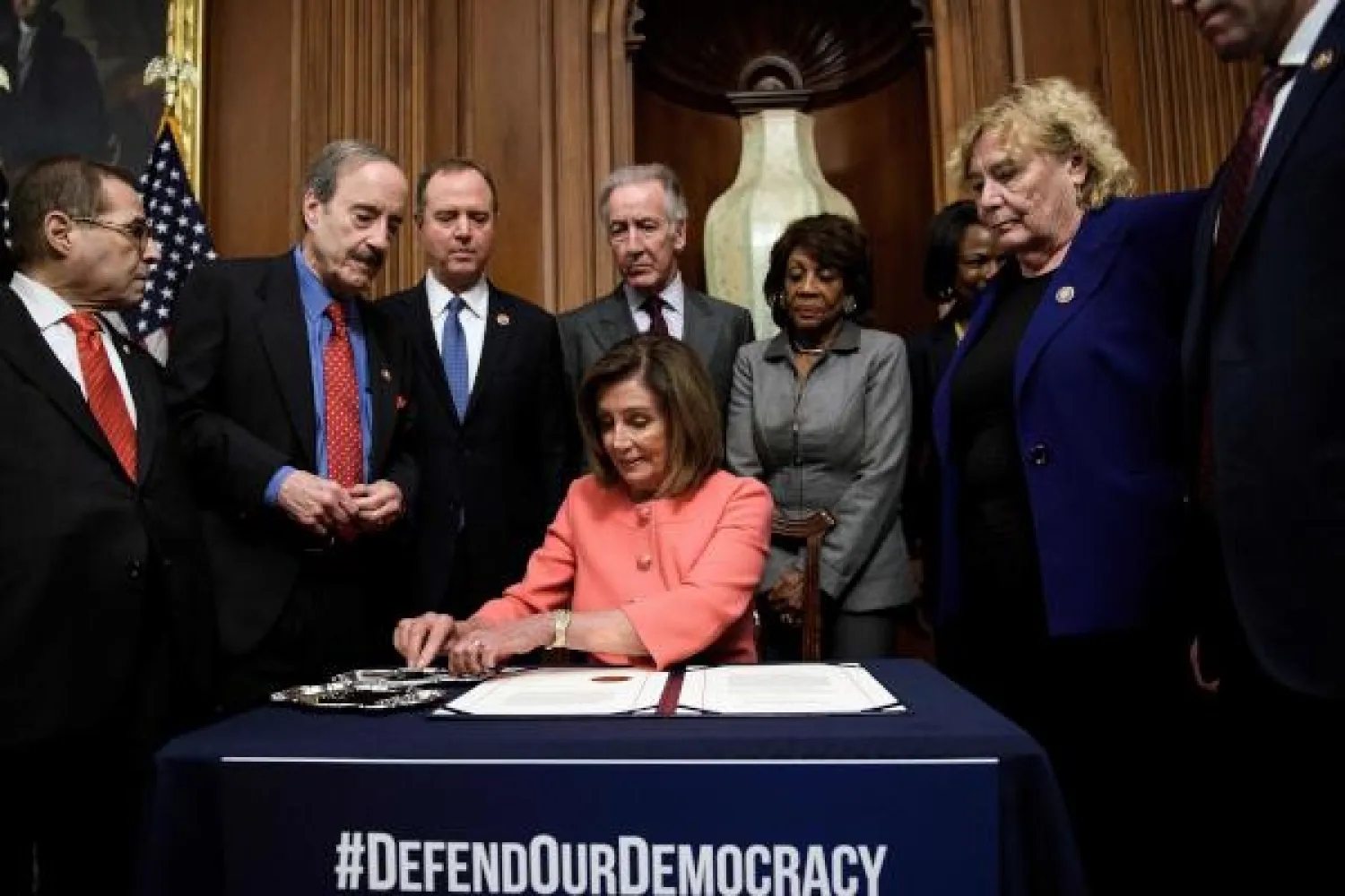رئيسة مجلس النواب نانسي بيلوسي خلال توقيعها على القرار الاتهامي بحق ترمب (ا.ف.ب)