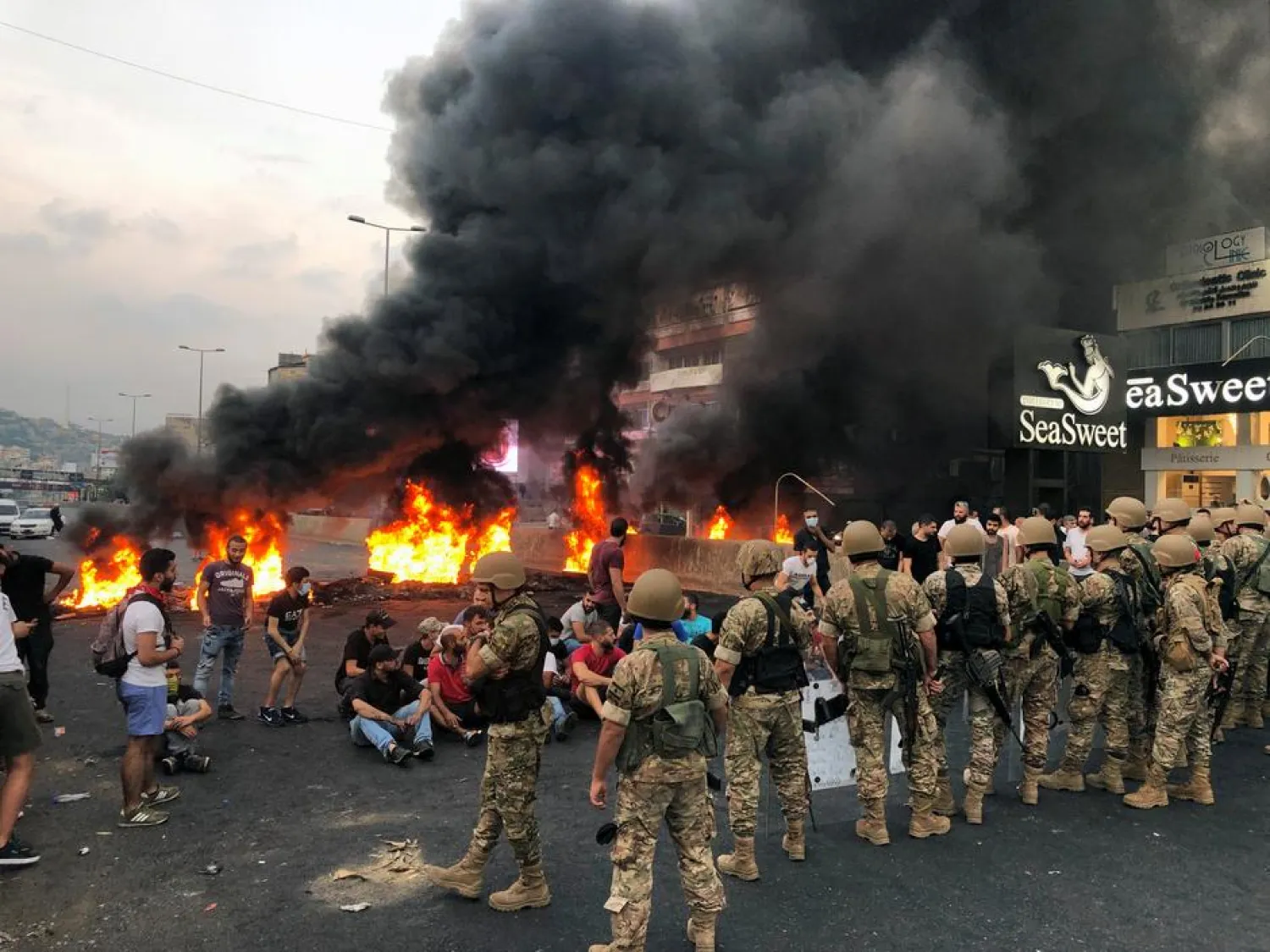 Demonstrators sit together during a protest over deteriorating economic situation, in the city of Jounieh, north of Beirut, Lebanon October 18, 2019. REUTERS/Imad Creidi

