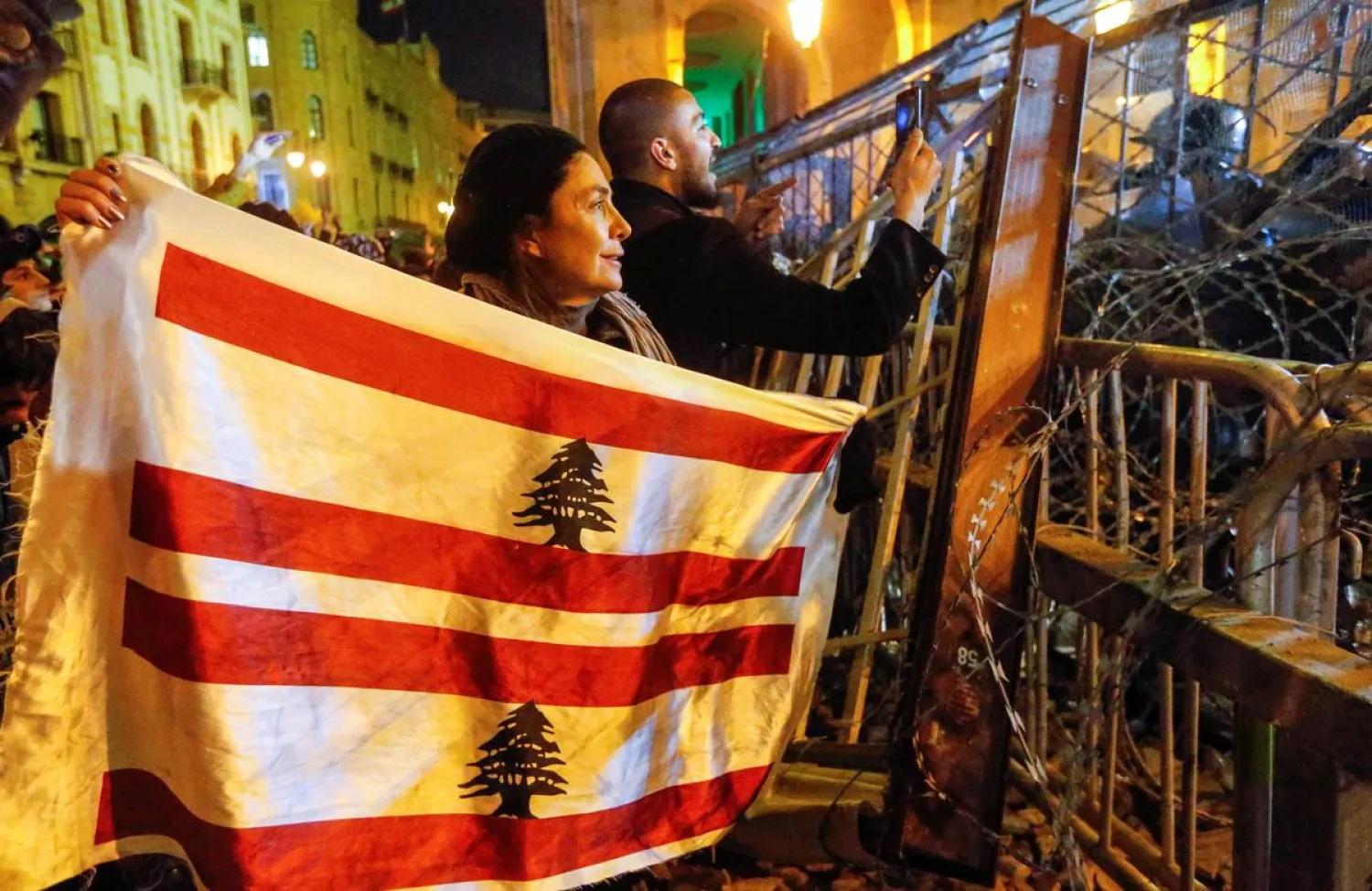A demonstrator holds the Lebanese flag during a protest against a ruling elite accused of steering Lebanon towards economic crisis in Beirut, Lebanon January 19, 2020. (Reuters)