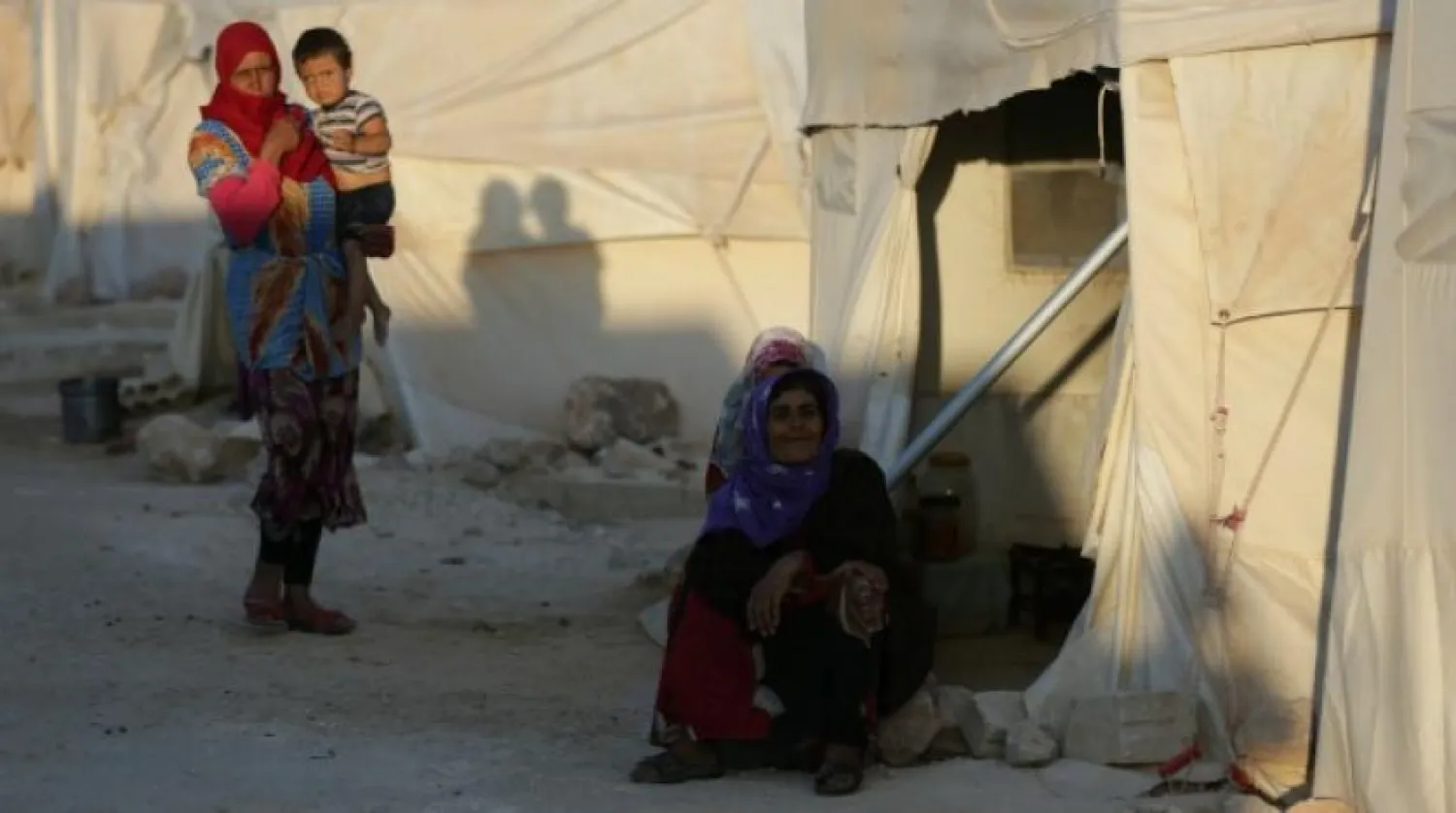 An internally-displaced woman sits outside a tent in Syria, July 30, 2018. (Reuters)
