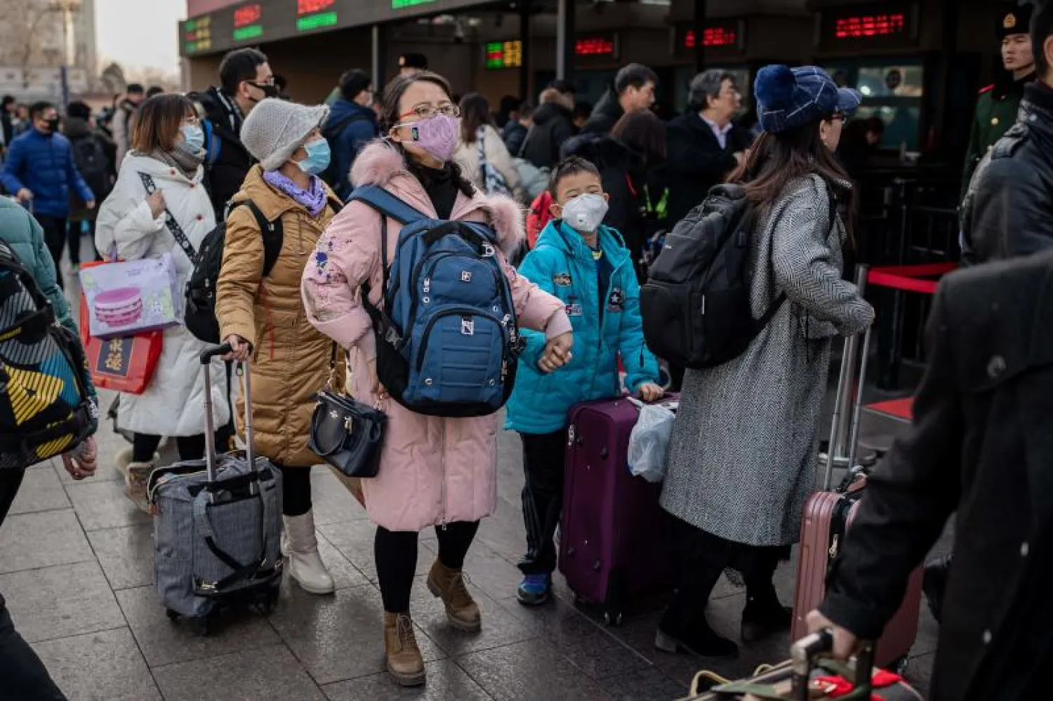 أشخاص يرتدون أقنعة واقية في محطة سكة حديد بالعاصمة الصينية بكين (أ.ف.ب)