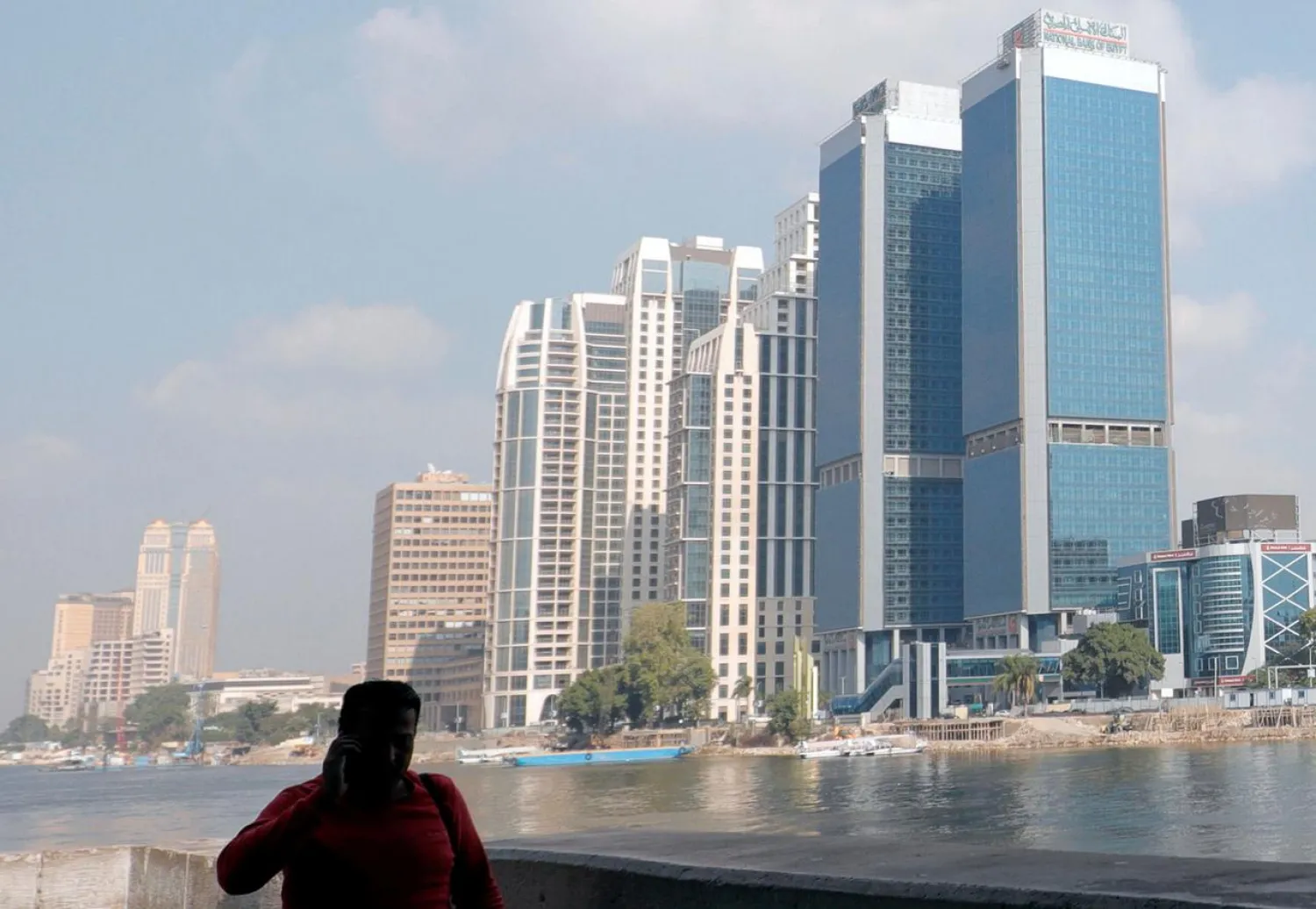 A man walks along the bank of the Nile River in front of high towers of hotels, banks and office buildings in Cairo, Egypt, December 17, 2019. (Reuters)