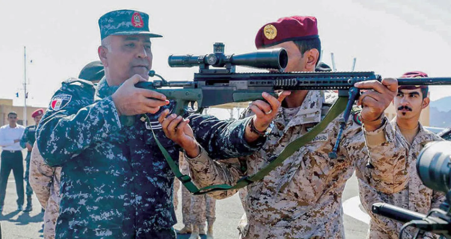 قائد قاعدة البحر الأحمر البحرية يستعرض سلاح أحد جنود البحرية السعودية  المشاركين في تمرين «مرجان - 16» (واس)