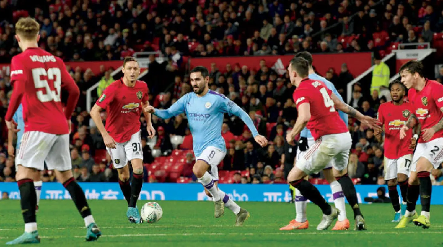 غوندوغان لاعب سيتي محاصر بلاعبي مانشستر يونايتد خلال لقاء الذهاب بكأس الرابطة (أ.ف.ب)