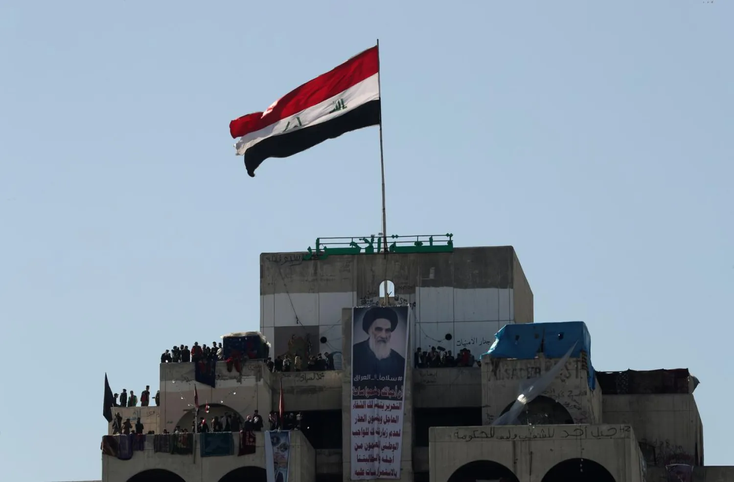 A poster of top religious authority Ali al-Sistani is seen as Iraqi protesters stand at the Turkish Restaurant building, during anti-government protests in Baghdad, Iraq January 26, 2020. (Reuters)