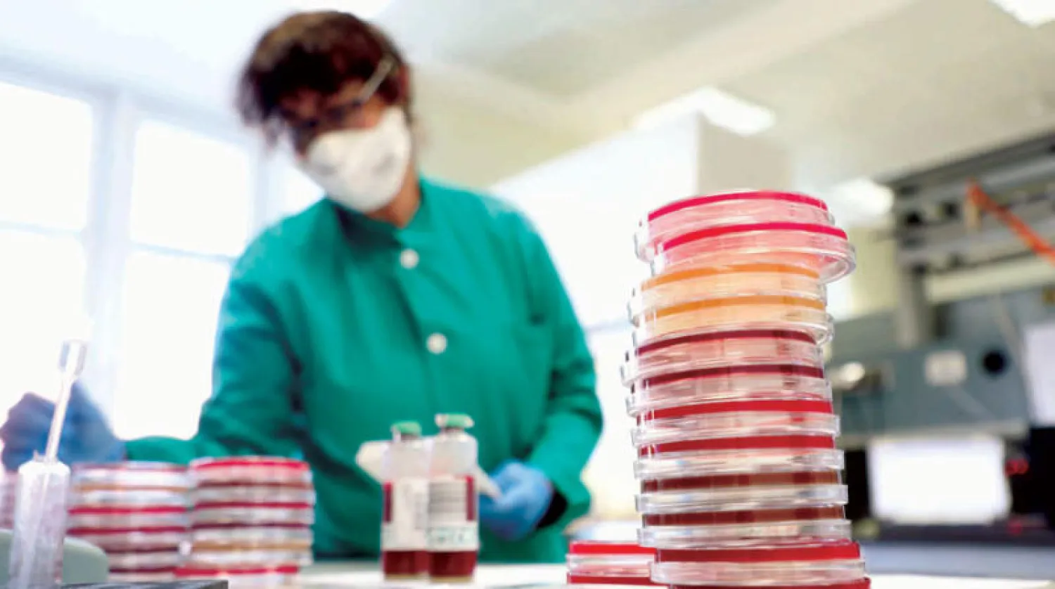 باحث داخل معمل للأحياء الدقيقة وعلوم الفيروسات في ميلانو بإيطاليا (إ.ب.أ)