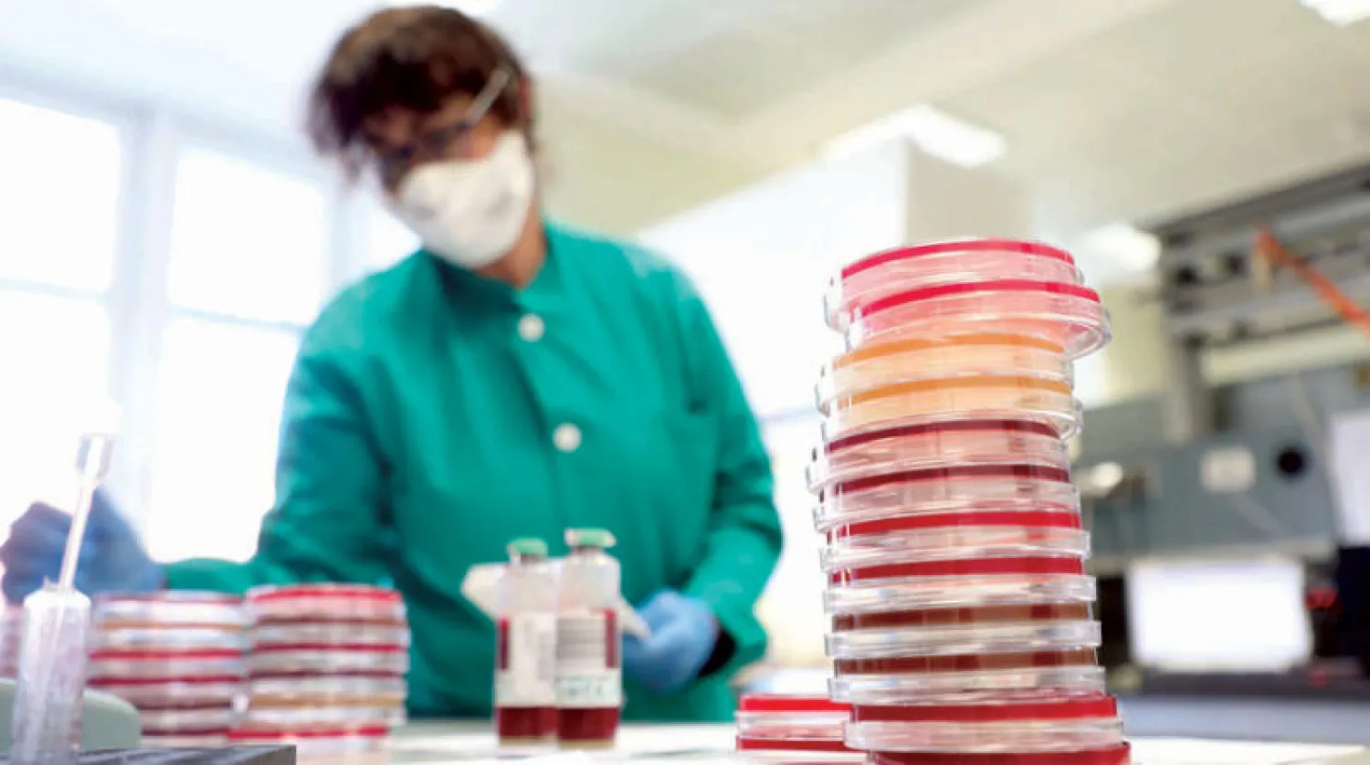 باحث داخل معمل للأحياء الدقيقة وعلوم الفيروسات في ميلانو بإيطاليا (إ.ب.أ)