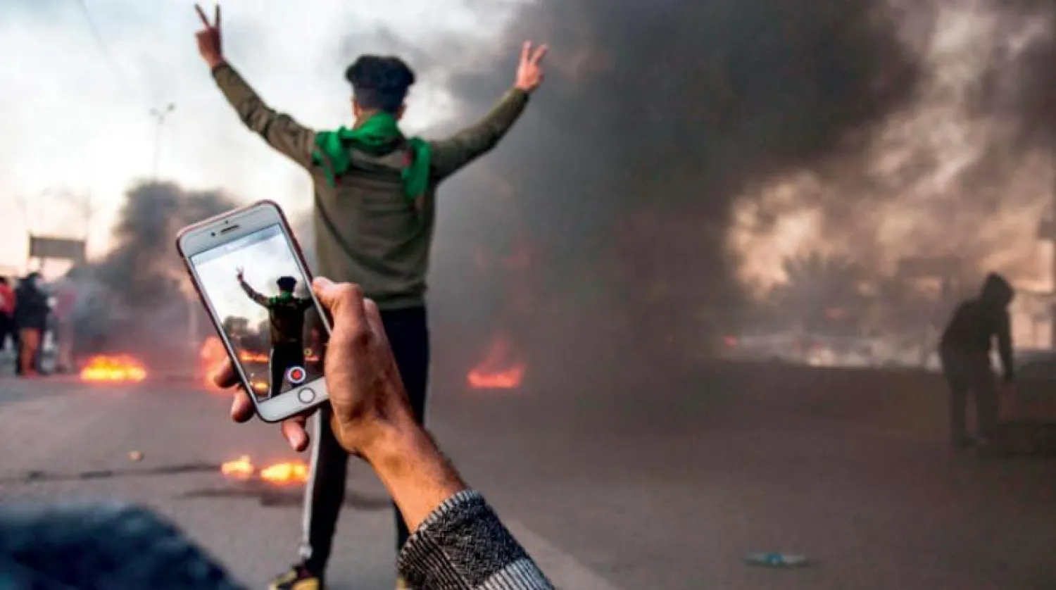Iraklı göstericiler cep telefonu kameralarıyla protestolarını kayıt altına alıyorlar (AFP)