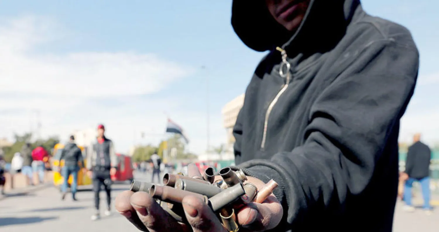 متظاهر يعرض أمس حفنة من أغلفة الرصاص وسط مزاعم عن استخدامها من قبل قوات الأمن (رويترز)