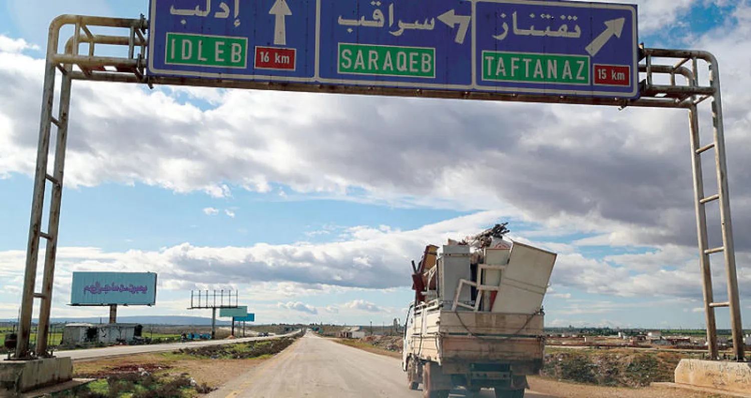 نازحون يمرون قرب سراقب في ريف إدلب شمال سوريا أمس (أ.ف.ب)