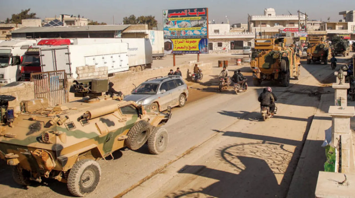 قافلة عسكرية  تركية تجتاز بلدة الدانا قرب الحدود السورية أمس (أ.ف.ب)