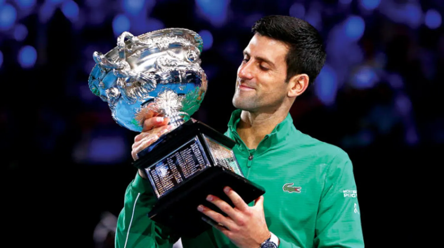 ديوكوفيتش يحتفل بكأس البطولة الأسترالية التي توج بها للمرة الثامنة (إ.ب.أ)