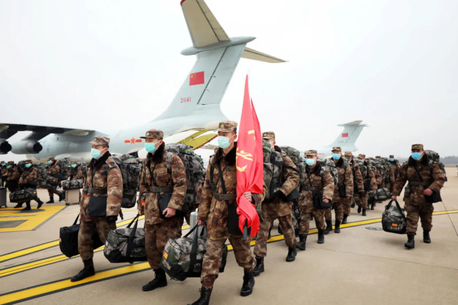 أفراد من الجيش الصيني يتجهون إلى المدن التي انتشر فيها الوباء (رويترز)