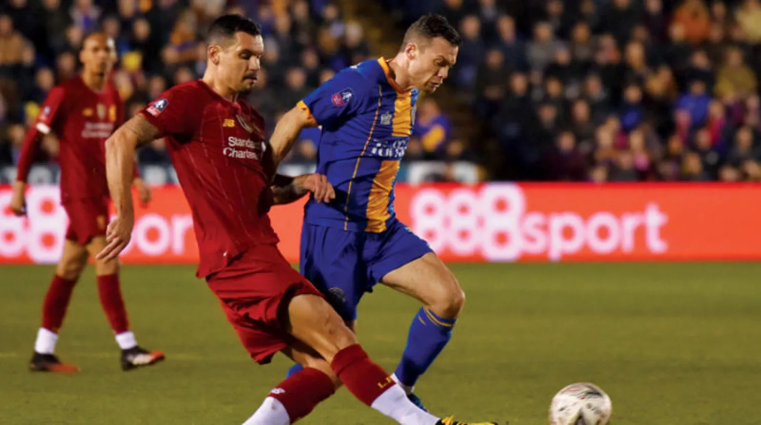 لوفيرن مدافع ليفربول (يسار) يحاول إيقاف شوان لاعب شروزبري في لقاء الجولة الأولى التي انتهت بالتعادل 2 - 2 (أ.ب)