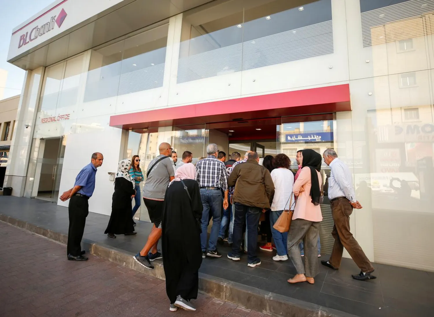 People queue outside a branch of BLC bank in Sidon, Lebanon November 19, 2019. (Reuters)