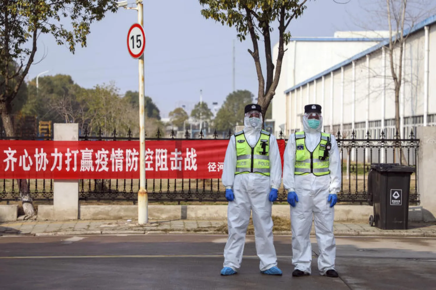 ضباط شرطة يرتدون بدلات واقية خارج فندق يستخدم للأشخاص  في عزلة طبية بمقاطعة هوبى وسط الصين  (ا.ب)