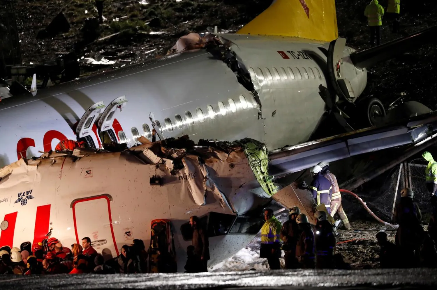 First responders work around the broken-up fuselage of the Pegasus Airlines plane that overran the runway and crashed, at Istanbul's Sabiha Gokcen airport, Turkey February 5, 2020. (Reuters)