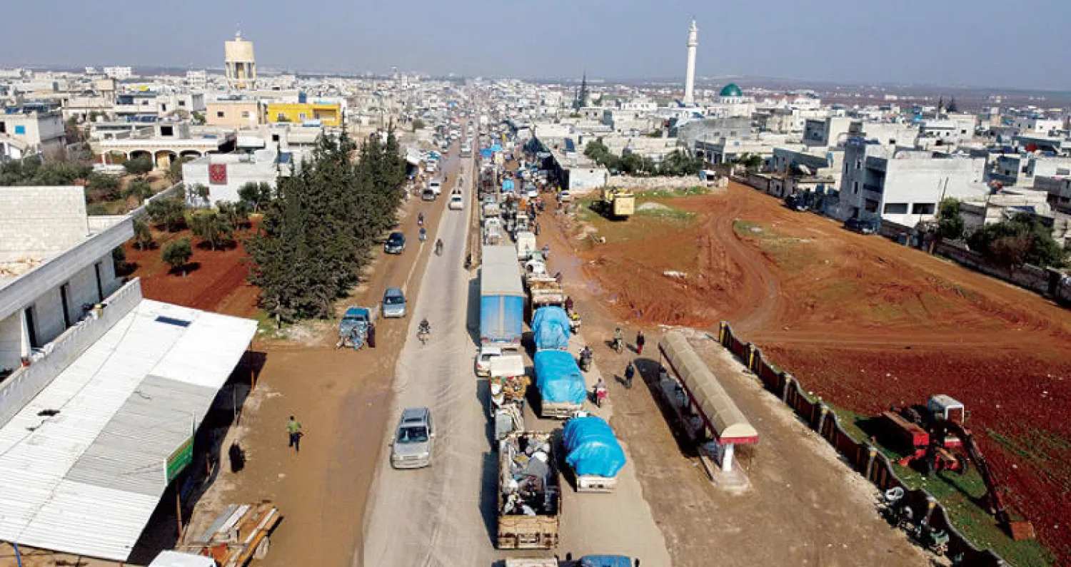 نازحون يعبرون في بلدة حزانو في ريف إدلب أمس (أ.ف.ب)