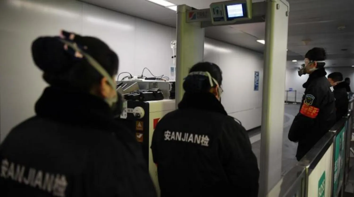 Güvenlik görevlileri, Pekin metro istasyonunda sağlık taramasında bulunuyor (AFP) 