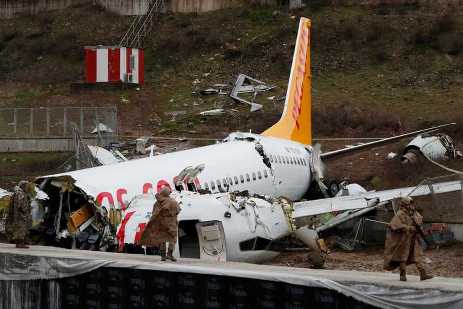 Soldiers stand guard near the Pegasus Airlines Boeing 737 plane wreckage, after it overran the runway during landing and crashed, at Istanbul's Sabiha Gokcen airport, Turkey February 6, 2020. Reuters/Murad Sezer