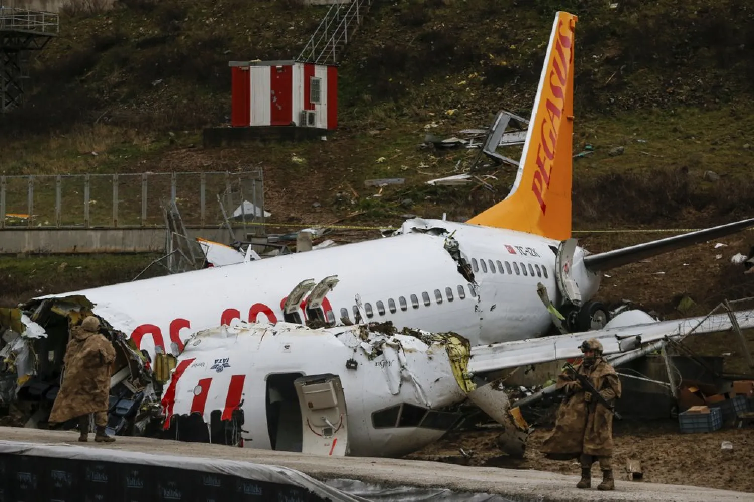 Turkish soldiers guard the wreckage of a plane operated by Pegasus Airlines after it skidded Wednesday off the runway at Istanbul's Sabiha Gokcen Airport, in Istanbul, Thursday, Feb. 6, 2020. (AP)