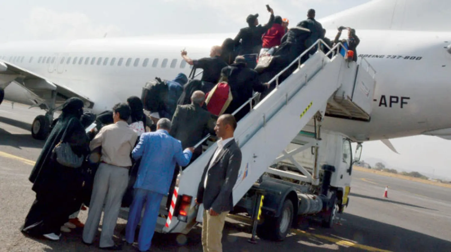 مرضى يمنيون ومرافقوهم لدى صعودهم ثاني طائرات «جسر الرحمة» التي أقلعت صوب العاصمة الأردنية لعلاجهم أمس (إ.ب.أ)