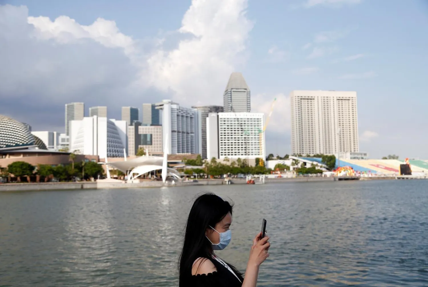 FILE PHOTO: A tourist wearing a protective face mask takes photos at the Merlion Park in Singapore, January 28, 2020. REUTERS/Feline Lim