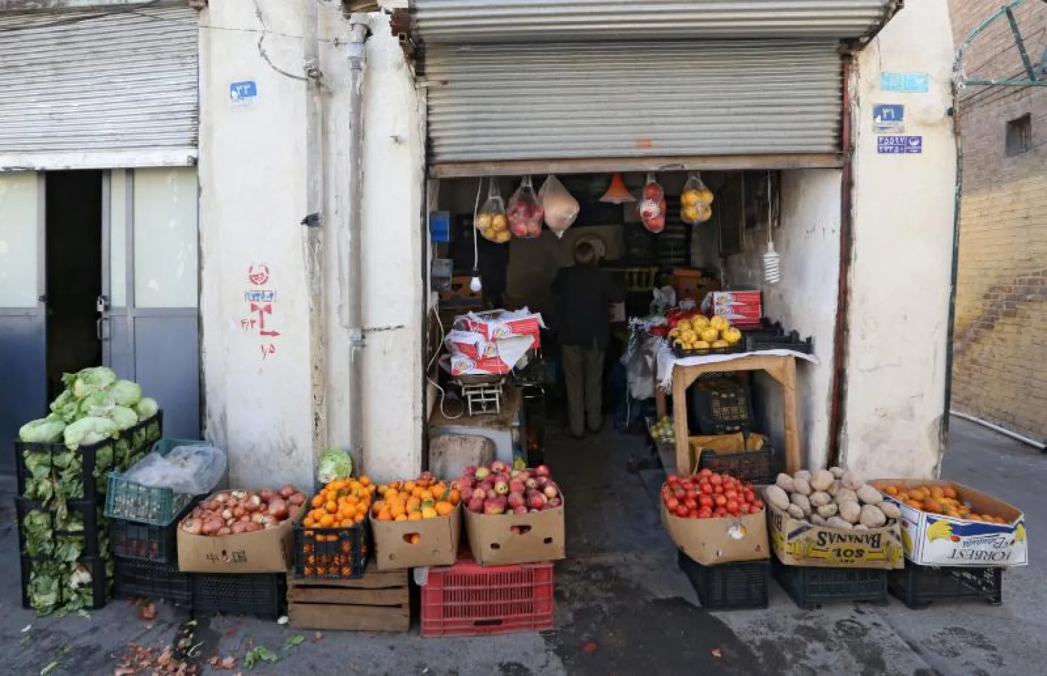 إيراني في متجر يبيع فيه الخضار في جنوب طهران (أ.ف.ب)