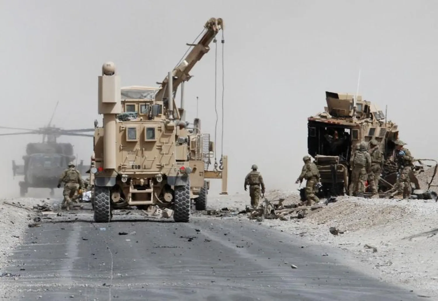 U.S. troops assess the damage to an armoured vehicle of NATO-led military coalition after a suicide attack in Kandahar province. REUTERS/Ahmad Nadeem
